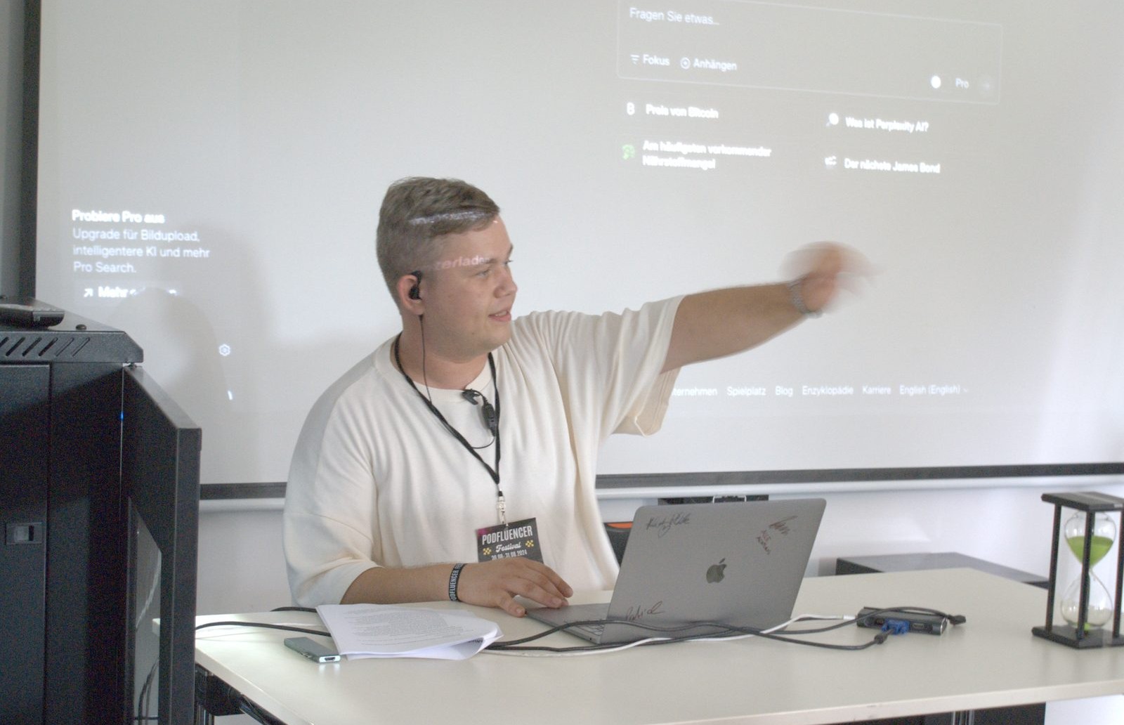 Ein Speaker zeigt bei einem Workshop am Laptop auf die Leinwand mit Software-Oberfläche